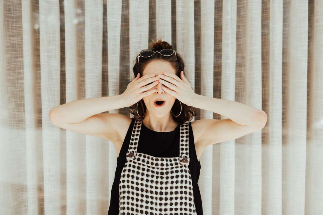 A woman playfully covering her eyes with her hands